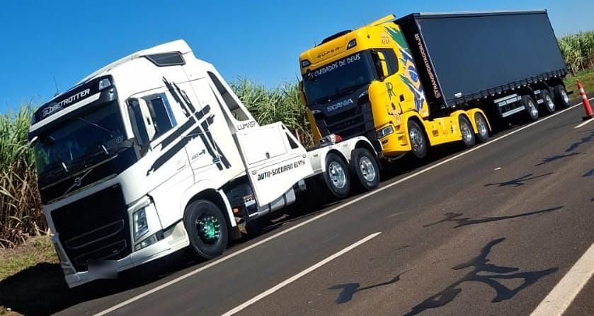 Guincho pesado rebocando um caminhão na rodovia